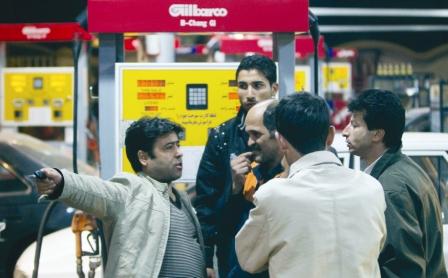 رجل يتحدث إلى عامل في محطة بنزين في طهران بشأن أسعار الوقود أمس